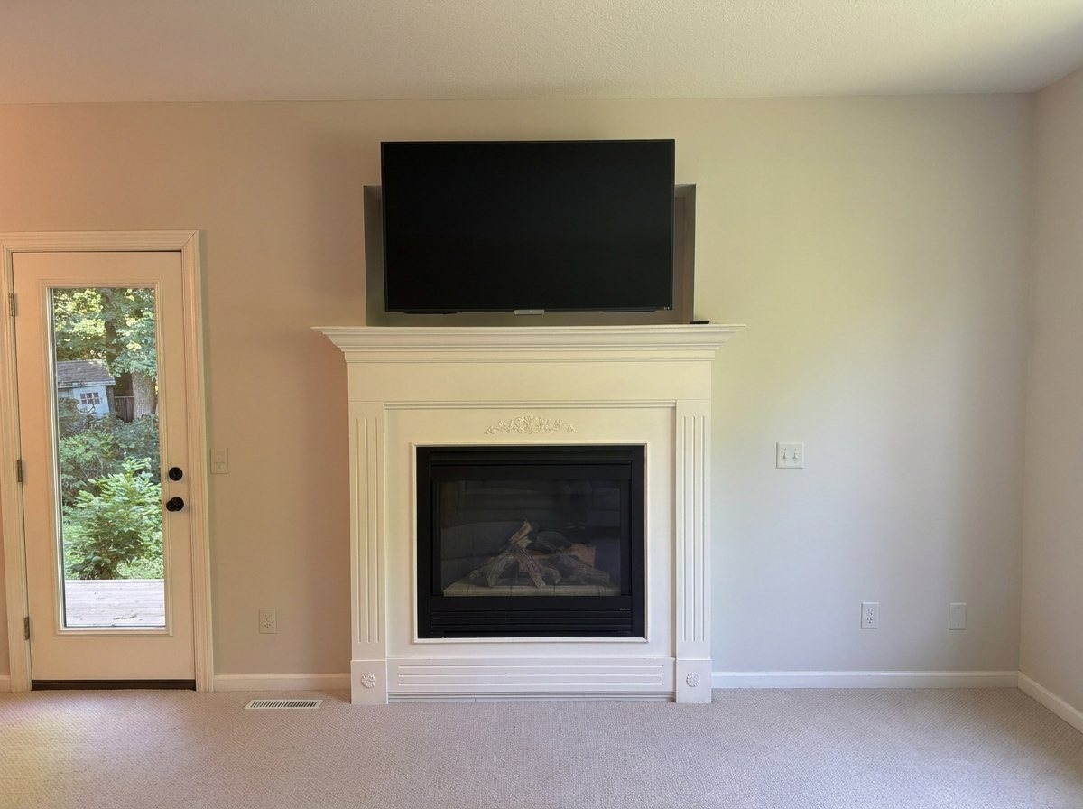 Living room before: dated cream fireplace surround, carpet, beige walls